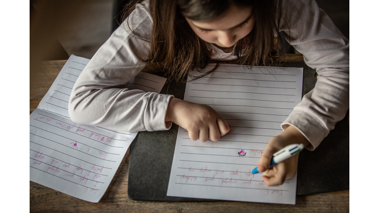 child writing letters to her friends