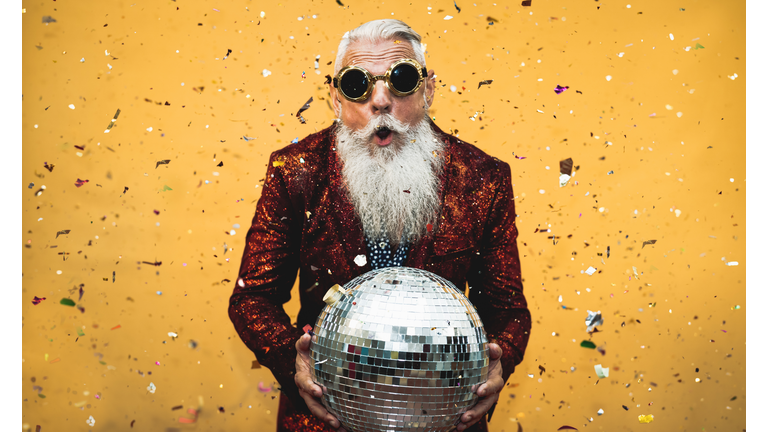 Crazy senior man having fun doing party during holidays time - Elderly people celebrating life concept