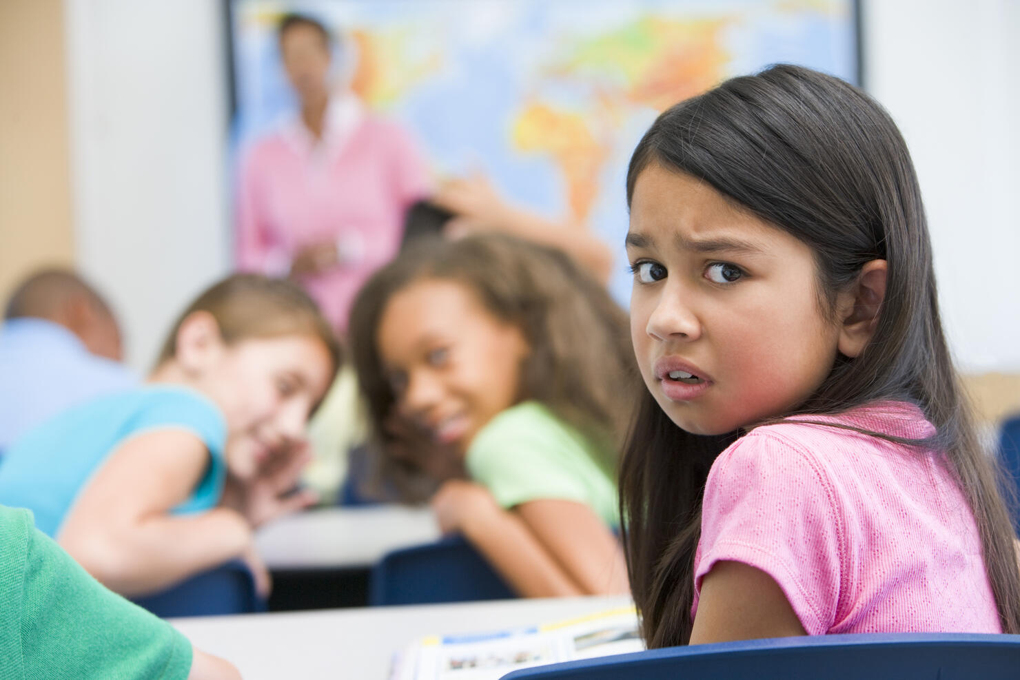 Student in class being bullied by students in background (selective focus)