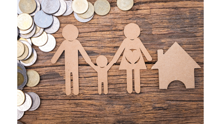 Directly Above Shot Of Coins And Cardboard Family Arranged On Wooden Table