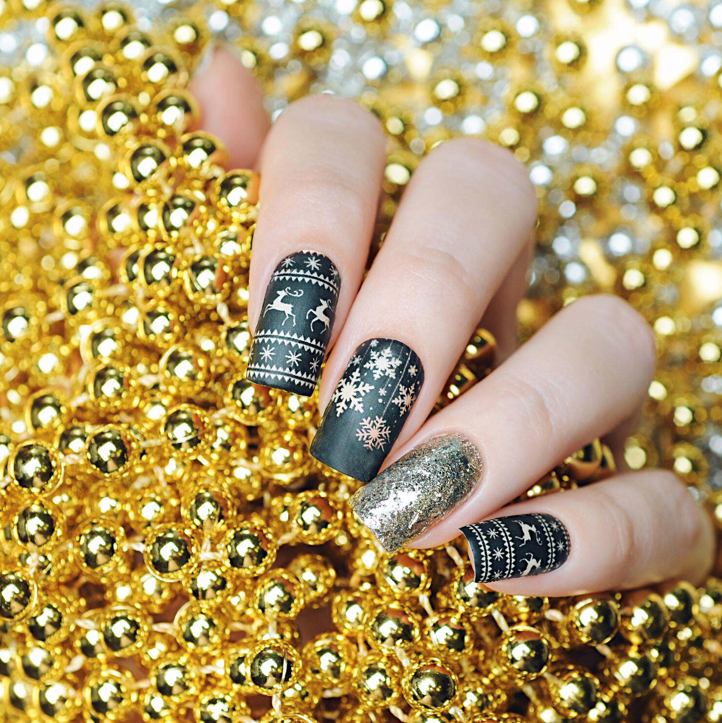 A black and gold Christmas manicure with deer and snowflakes!