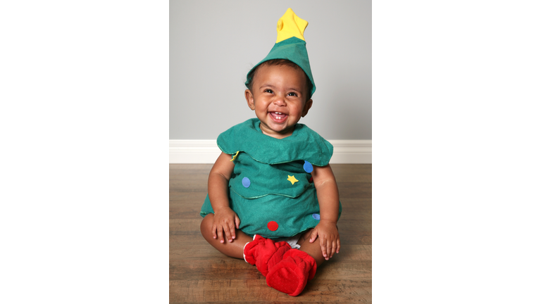Laughing baby boy in green Santa's elf outfit