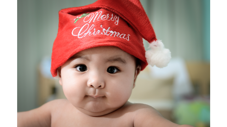 Cute shirtless baby boy wearing Santa hat