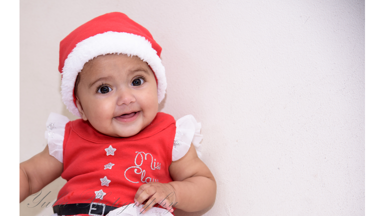 Cheerful baby wearing Santa hat 