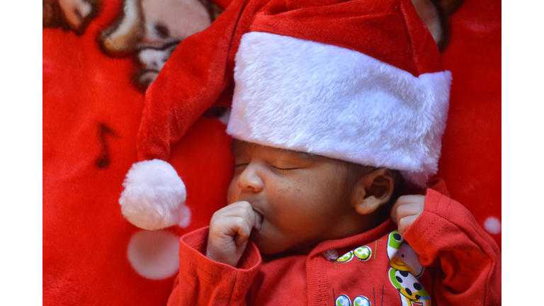 Sleeping baby boy dressed in red Christmas outfit