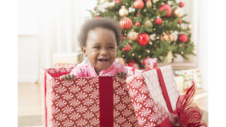 Baby girl playing in Christmas gift box