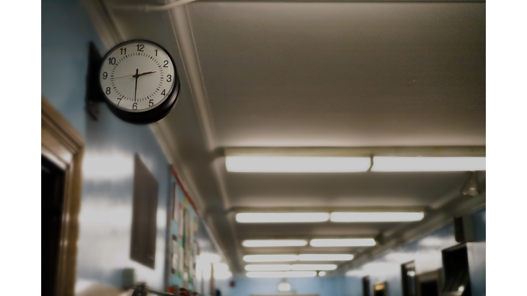 partial darkened view of school corridor with defocused exit sign in the background