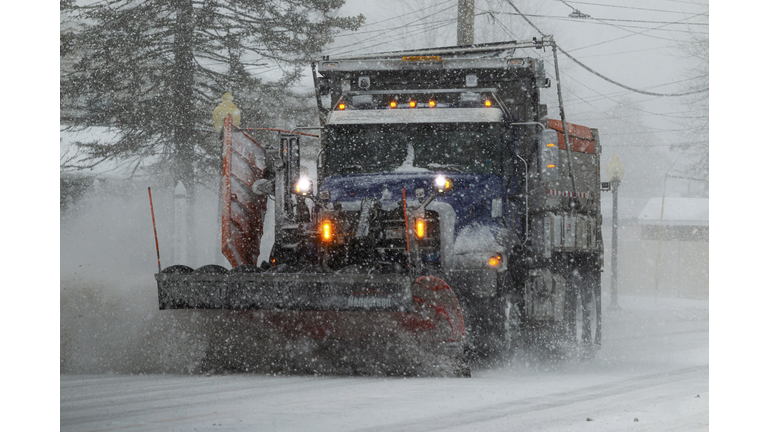 Snowplow clearing the street during a blizzard