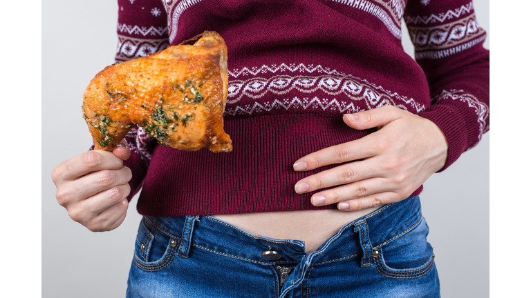 Junk food eating too much concept. Cropped close up photo of girl holding hands palm on big full abdomen feeling heartburn after fatty greasy nutrition isolated grey background