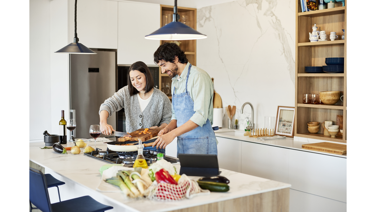 Woman Helping Boyfriend In Preparing Meal At Home