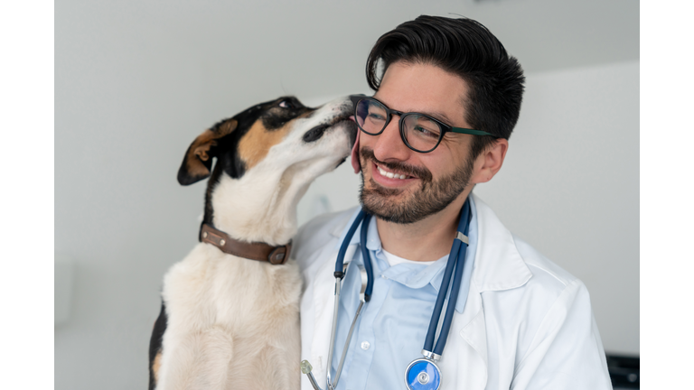 Very happy veterinarian getting a kiss from a dog