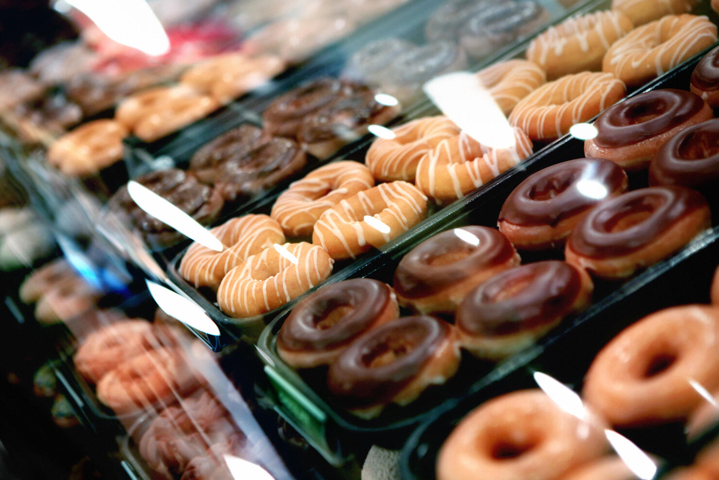 Variety of donuts on a tray in a display case