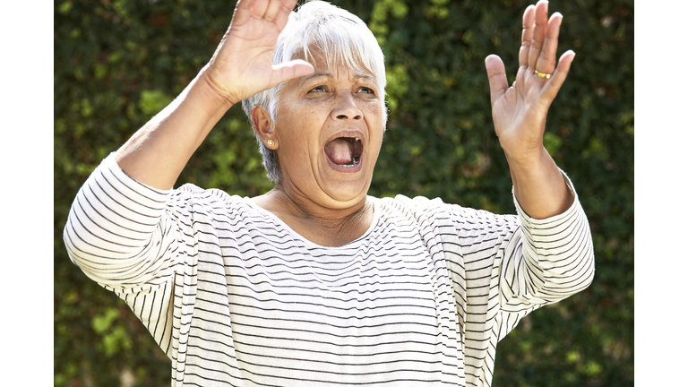 Portrait of shocked senior woman in her garden