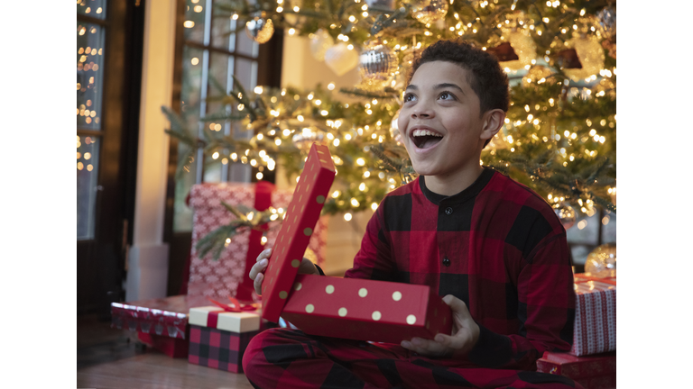 Mixed race teenager boy opening Christmas presents