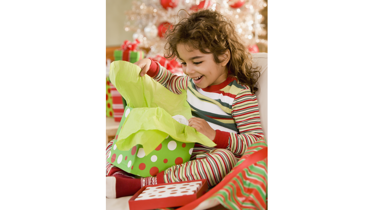 Hispanic girl opening gift