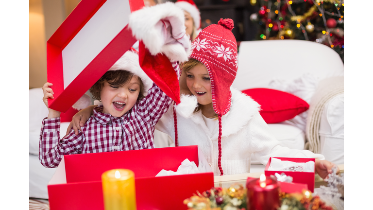 Festive little siblings opening a gift