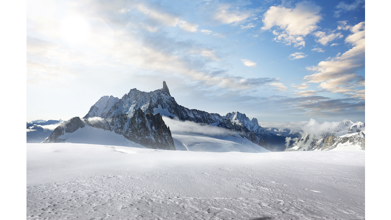 Jagged mountain peaks jutting out of a snow covered landscape.