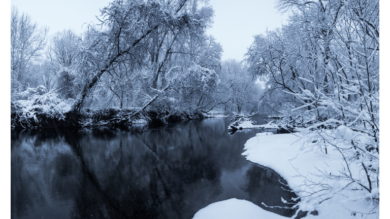 Scenic view of frozen lake surrounded by a snowy landscape.