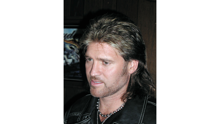 Closeup of Billy Ray Cyrus with a gold chain around his neck.