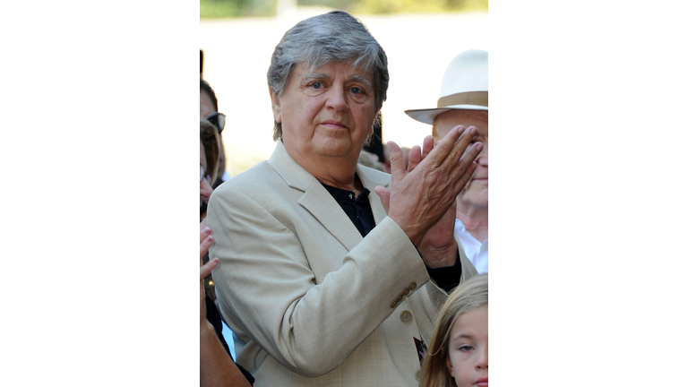 Guitarist Phil Everly wearing a white suit and standing in a crowd of people.