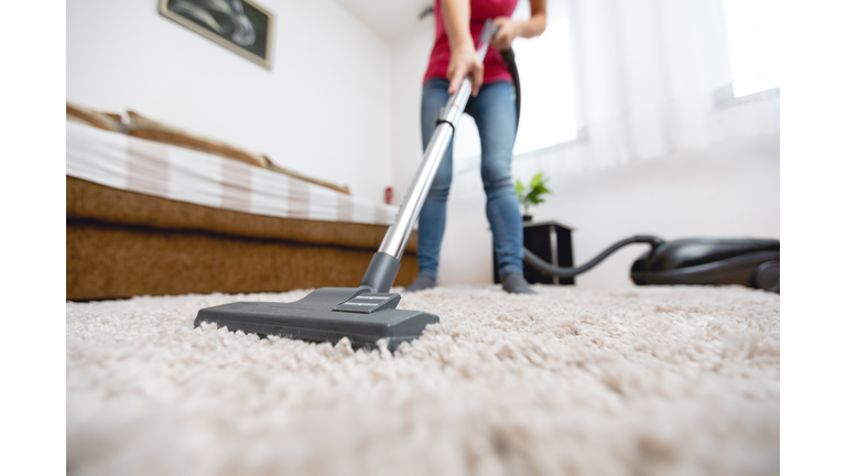 Young woman vacuuming house