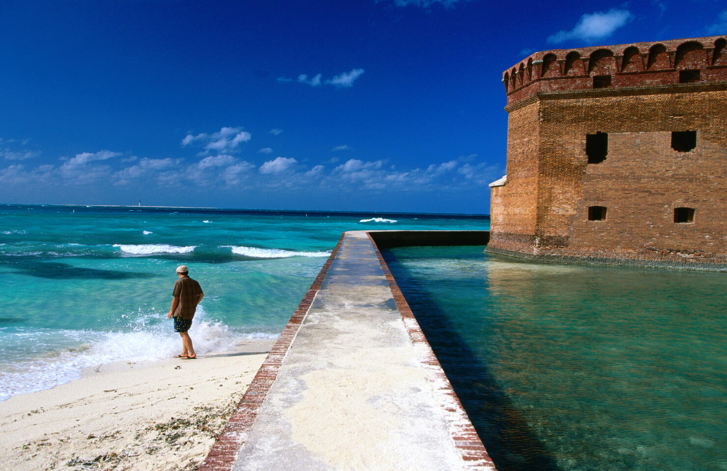 Tourist near moat wall of Fort Jefferson, Garden Key.