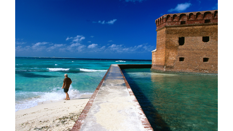 Tourist near moat wall of Fort Jefferson, Garden Key.