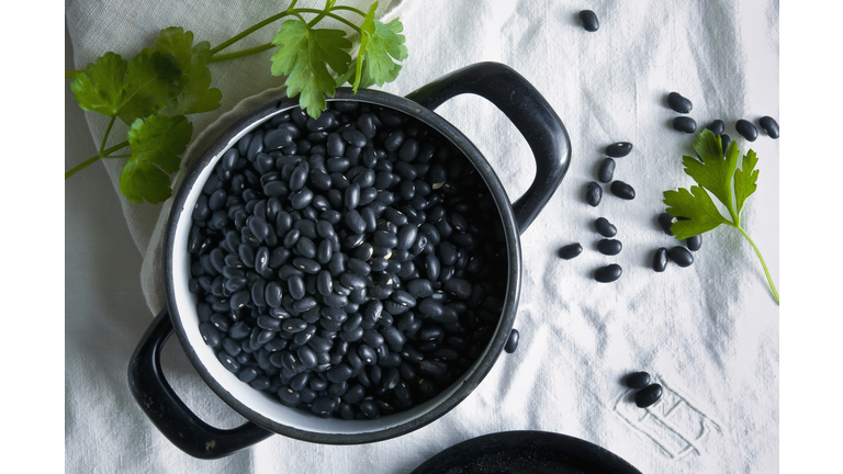 Directly above shot of black beans in cooking pan on tablecloth