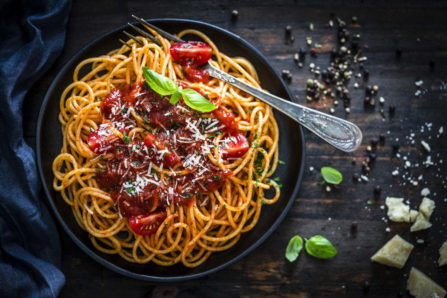 Spaghetti with tomato sauce shot on rustic wooden table