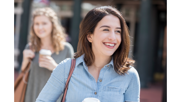 College student heads to class on campus with coffee