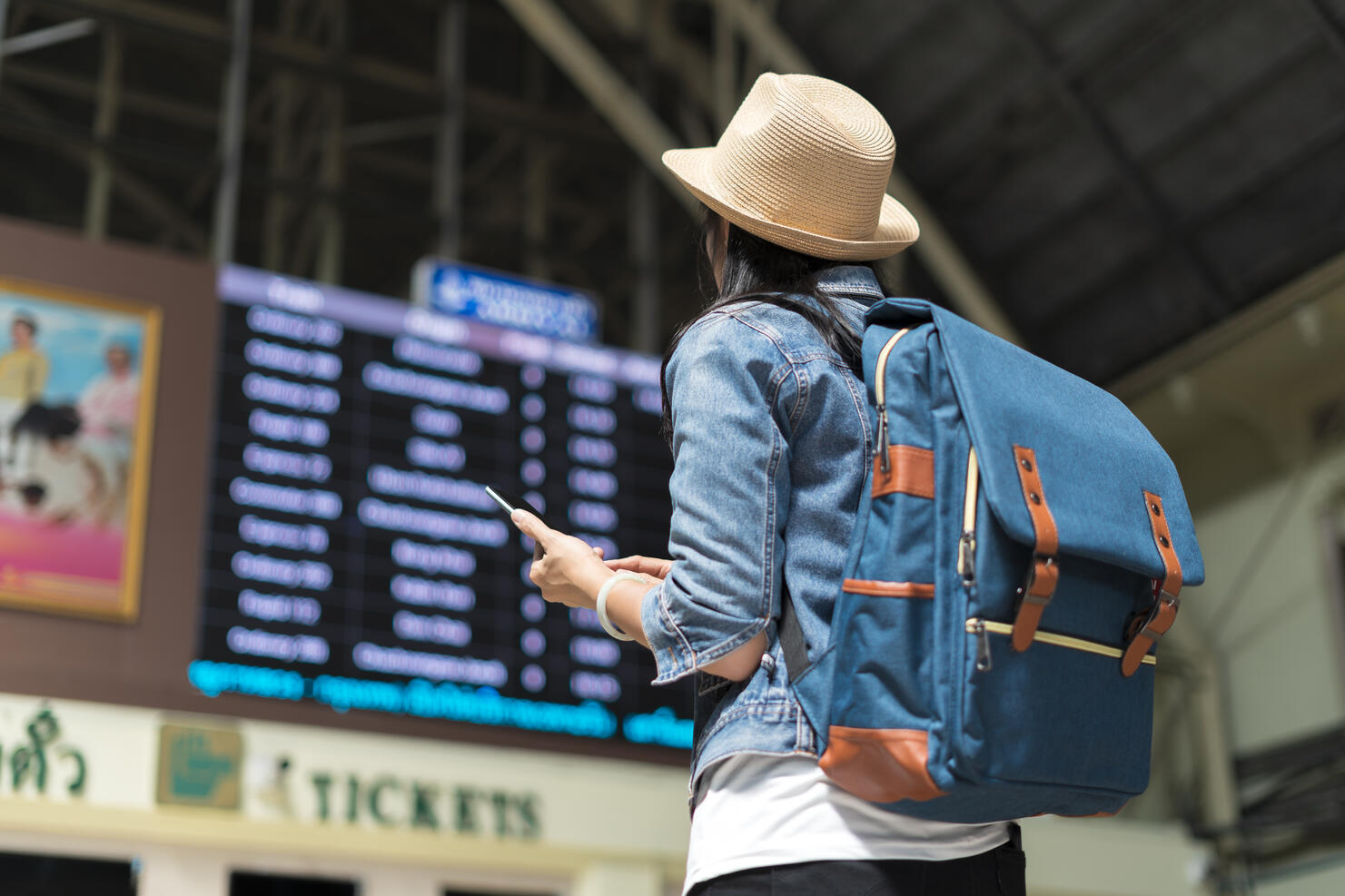 Young woman checking her train in timetable board