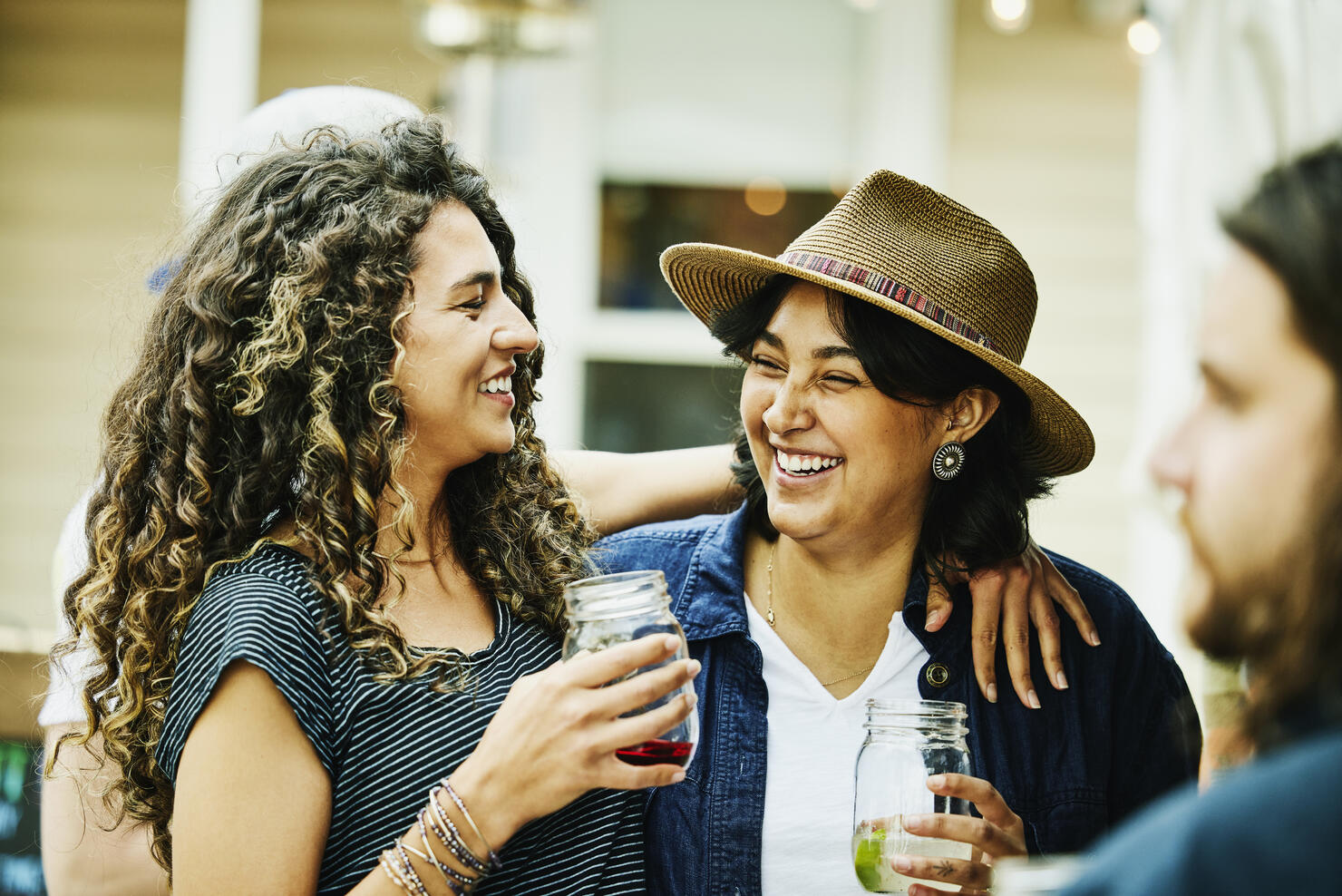 Medium shot of smiling female friends embracing while dining at food truck