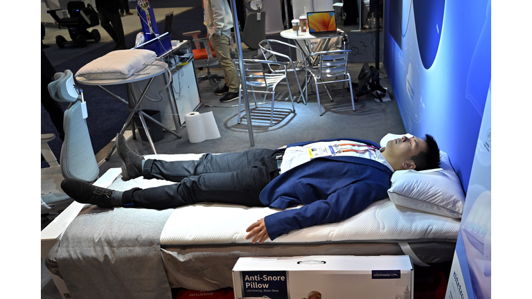 Man laying on a bed to demonstrate the anti-snore pillow.