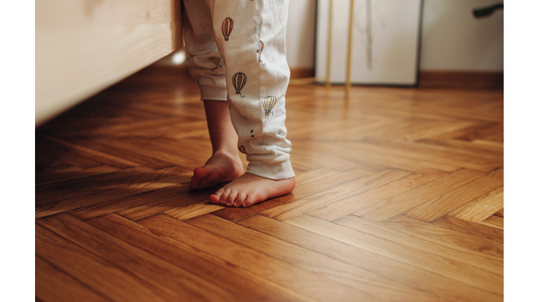 Close Up Shot of Child's Legs on the Wooden Floor