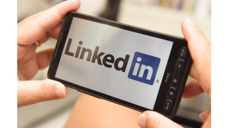 Woman holding a smartphone with linkedin logo