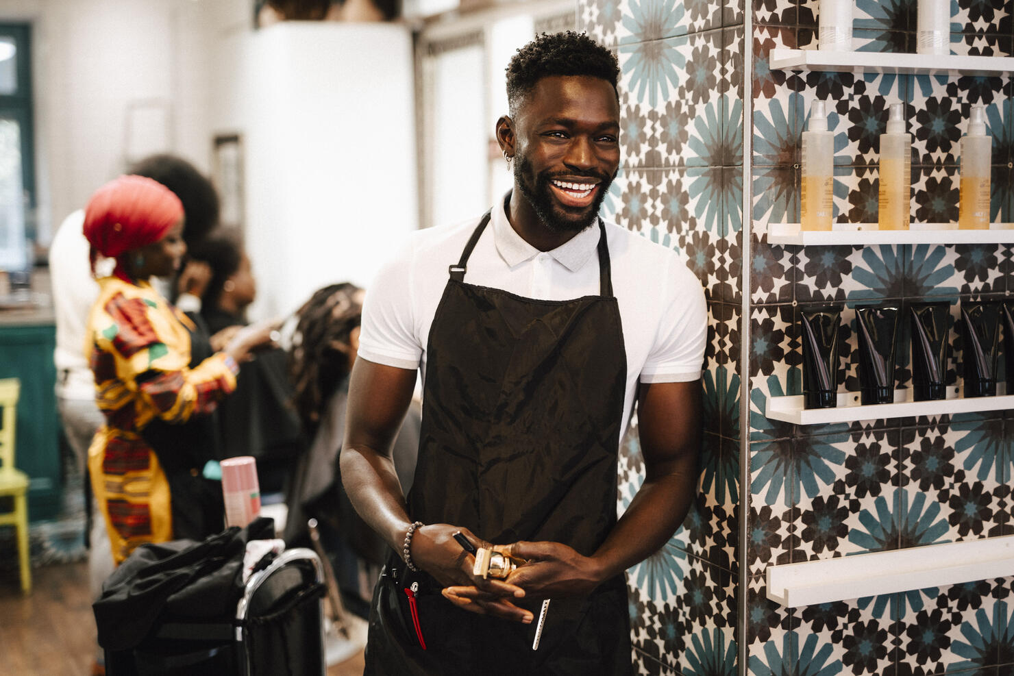 Cheerful male hairdresser looking away in barber shop