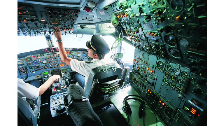 Pilot Switching a Control in the Cockpit of a Commercial Aeroplane