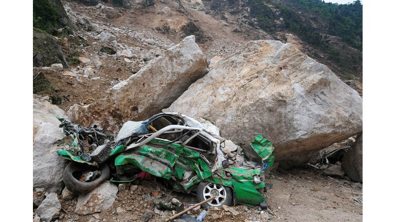 A demolished taxi crushed by boulders in