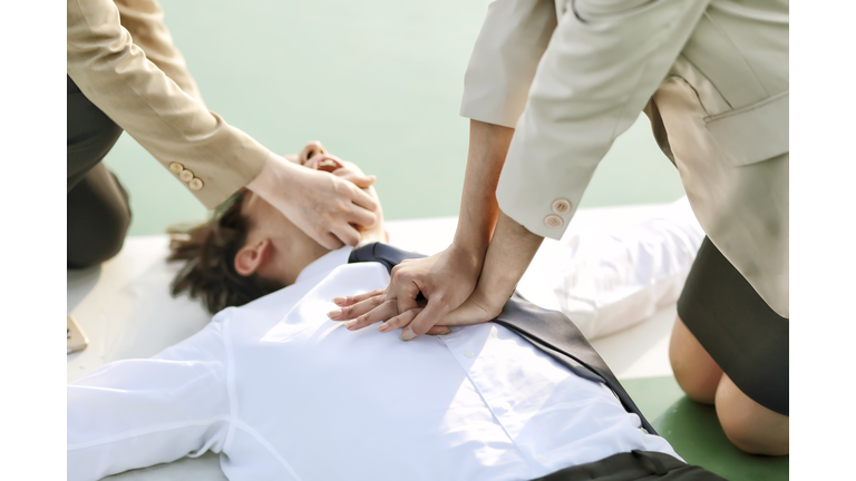 Businesswoman performing cardiopulmonary resuscitation