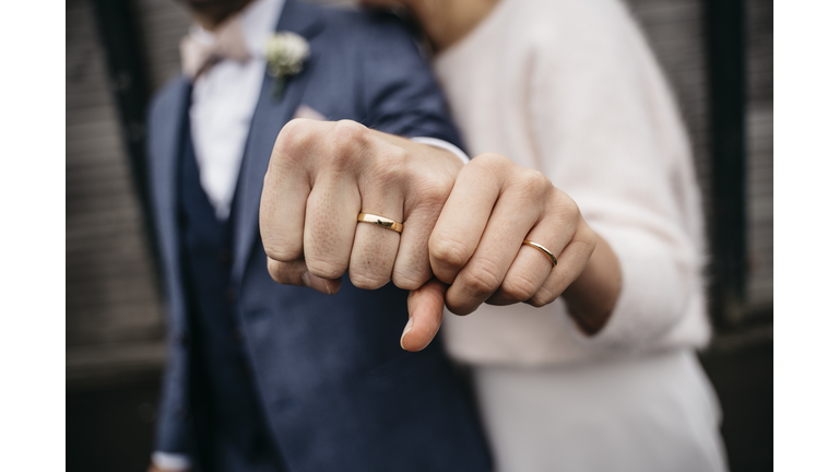 Newlywed couple showing their golden wedding rings