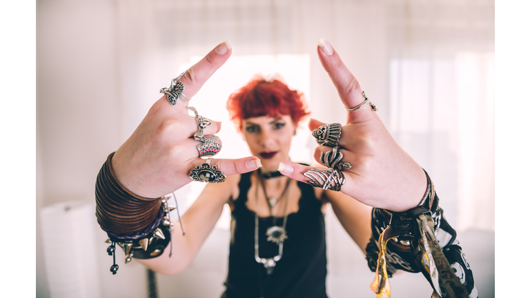 Metal girl showing devil horns gesture