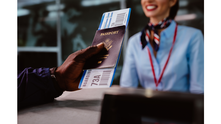 Man holding passport and boarding pass at airline check-in counter