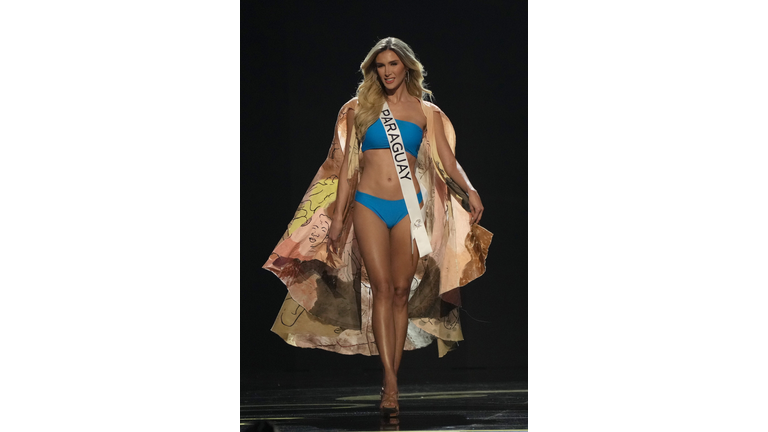 Blond in a blue swimsuit and peach colored cape.