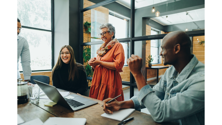 Diverse businesspeople smiling cheerfully during an office meeting