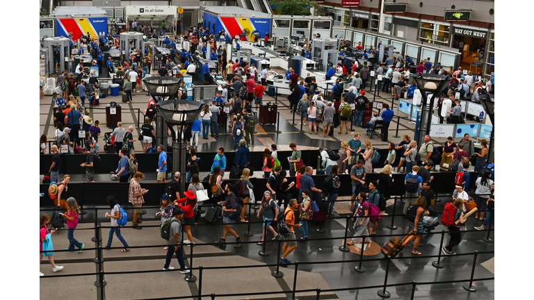 Crowds of travelers in long queue at TSA Security Check at Denver International Airport over summer holiday weekend.