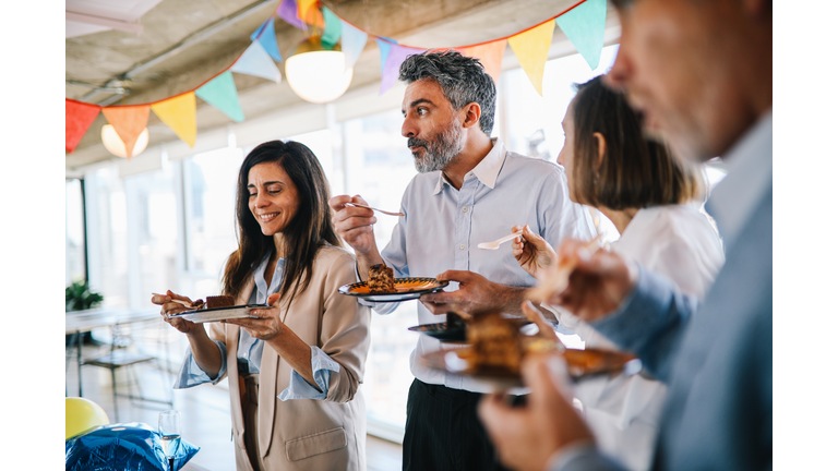 Colleagues eating cake at the office birthday party