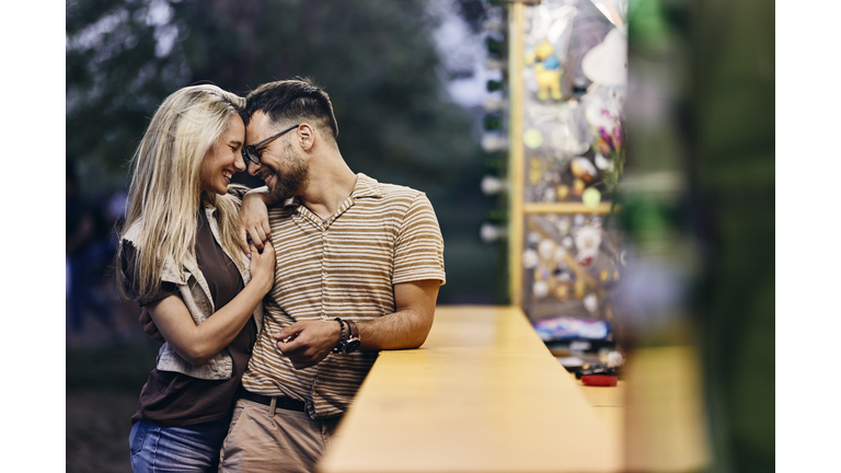 Happy couple in love at amusement park.