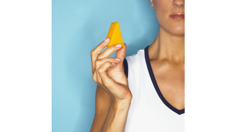 Woman holding piece of cheese
