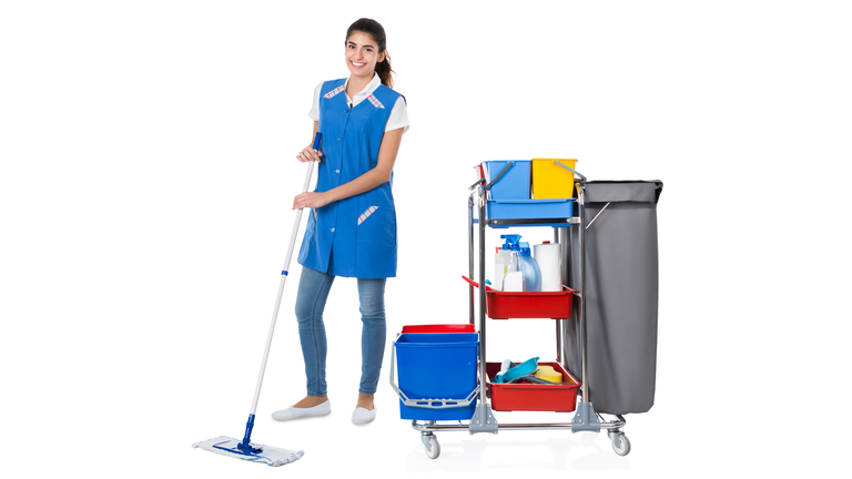 Happy Female Janitor Mopping By Trolley On White Background