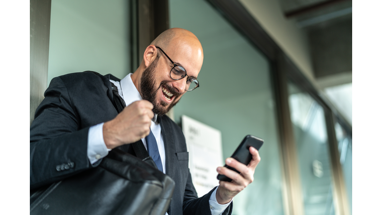 Business Man Celebrating Good News on Mobile